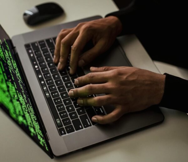 crop cyber spy hacking system while typing on laptop